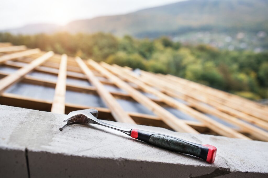 Hammer on the roof on the construction site.