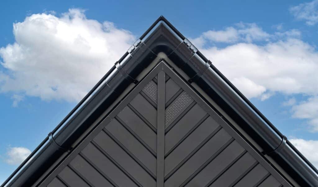 A modern graphite herringbone roof lining is attached to the trusses